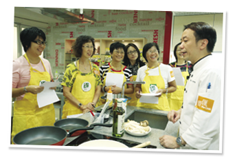 參加者留心聆聽名廚張錦祥指導。 Participants having fun while learning from the Celebrity Chef Ricky Cheung.